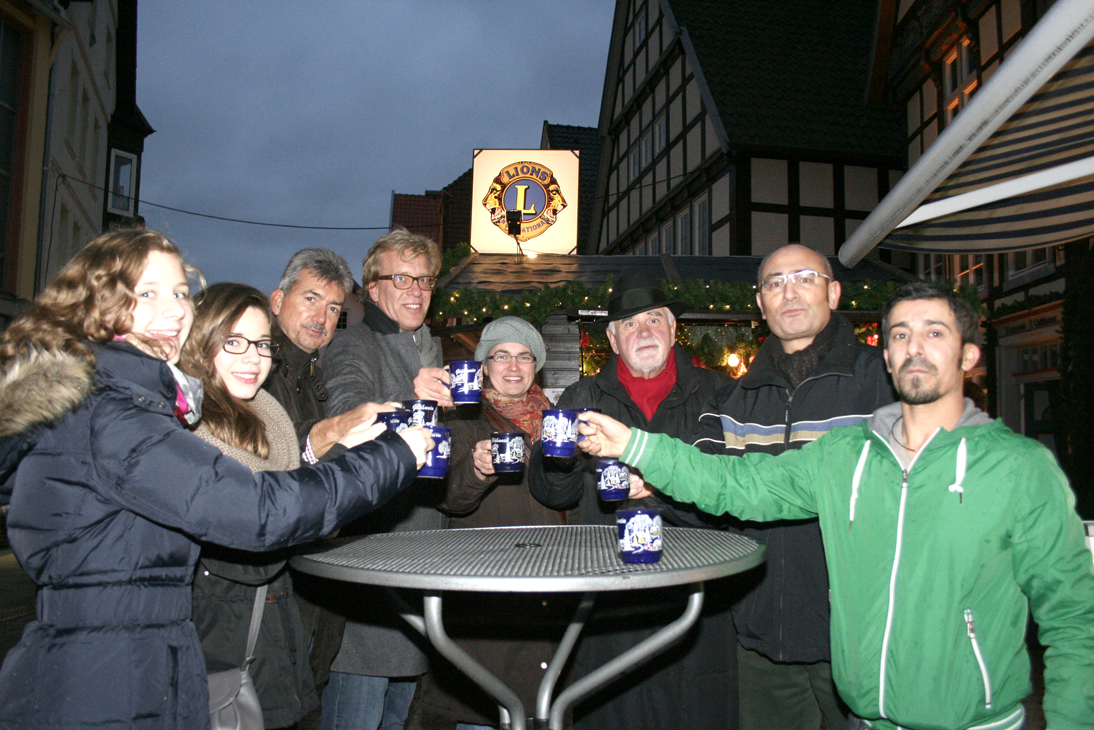 Menschen um einen Stehtisch mit Lions Glühwein